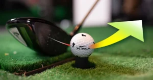 Close-up of a golf club striking an X-Golf ball with a trajectory arrow, visually illustrating what is ball speed in golf and how launch angle affects performance.