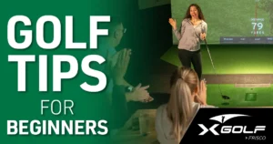 Smiling woman celebrates a golf shot on an indoor simulator screen while others applaud, with text reading “Golf Tips for Beginners” and the X-Golf Frisco logo.